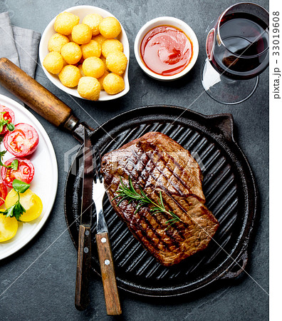 Grilled beef steak on grill pan served with tomato 33019608