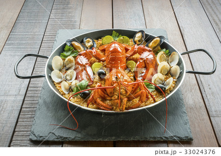 Paella with fresh lobster, clams, mussels and lime 33024376
