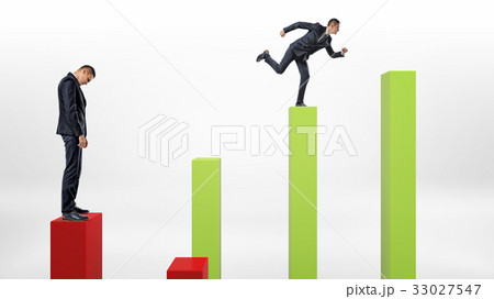 A sad businessman standing on a red column with a 33027547