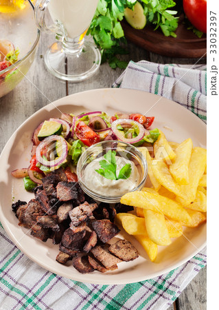 Grilled meat with French fries and vegetables Grilled meat with French fries and vegetables 33032397
