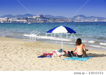 Ibiza sandy beach young girl under a umbrella 33033333