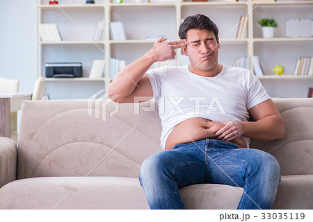 Man suffering from extra weight in diet concept 33035119