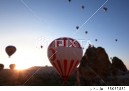 Blurred view on hot air balloons and blue sky Blurred view on hot air balloons and blue sky 33035882