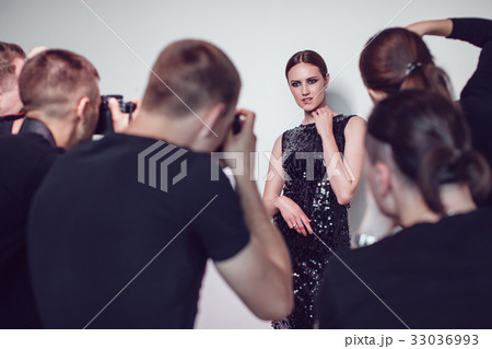 Photographers paparazzi take photos of woman in 33036993