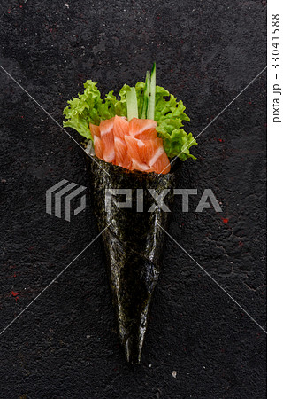 Salmon handmade sushi (temaki) on a stone plate. 33041588