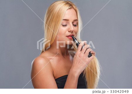 Young sexy blonde is vaping. Studio shooting, Young sexy blonde is vaping. Studio shooting, 33042049