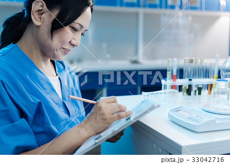 Joyful nice woman writing in her notebook 33042716