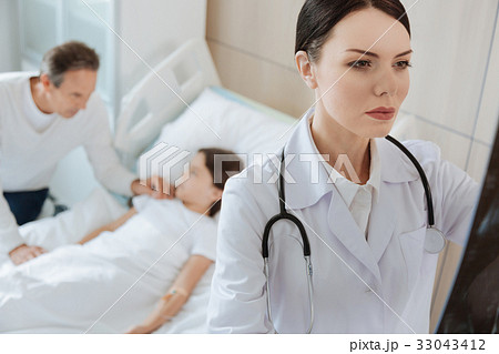 Beautiful smart doctor studying an X ray photo 33043412