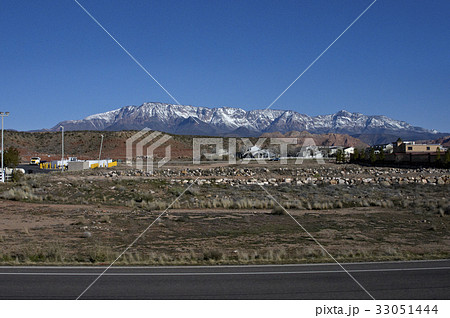 冠雪している山脈に抱かれた小さな村 33051444