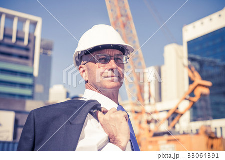 Senior elegant builder man in suit at construction site on sunny Senior elegant builder man in suit at construction site on sunny 33064391