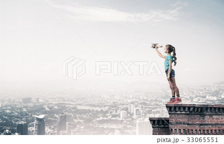 Concept of careless happy childhood with girl dreaming to become 33065551