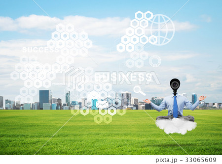 Camera headed man sitting in lotus pose on cloud against modern cityscape 33065609