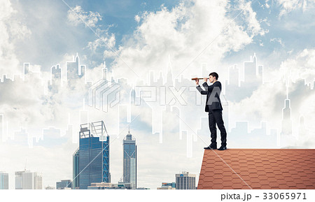 Engineer man standing on roof and looking in spyglass. Mixed med Engineer man standing on roof and looking in spyglass. Mixed med 33065971