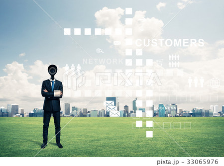 Camera headed man standing on green grass against modern citysca Camera headed man standing on green grass against modern citysca 33065976