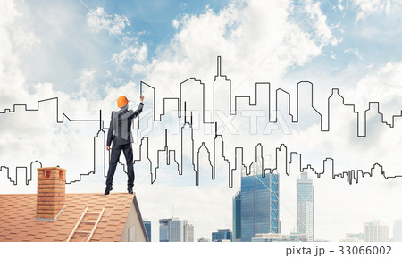 Man architect draw silhouette of modern city on blue sky. Mixed 33066002
