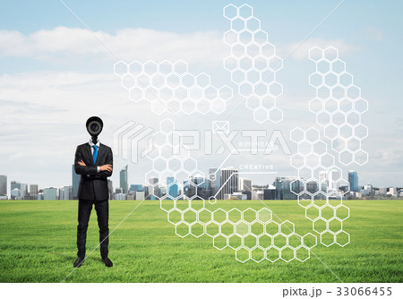 Camera headed man standing on green grass against modern cityscape Camera headed man standing on green grass against modern cityscape 33066455