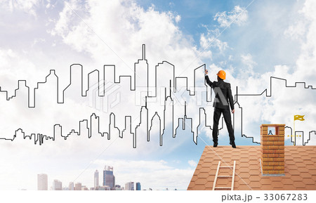 Man architect draw silhouette of modern city on blue sky. Mixed media 33067283