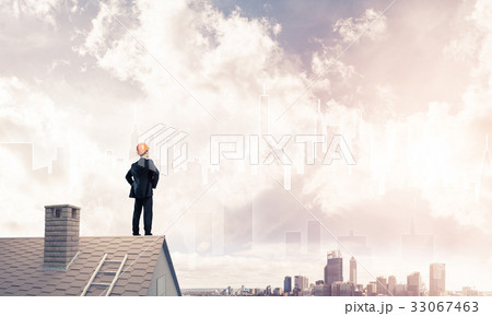 Engineer man standing on roof and looking away. Mixed media 33067463