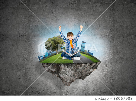 Cute boy of school age with book exploring this great world Cute boy of school age with book exploring this great world 33067908