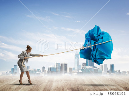 Woman pulling with effort big crumpled ball of paper as creativity sign 33068191