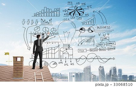 Rear view of businessman on house roof drawing his new business strategy. Mixed media 33068510