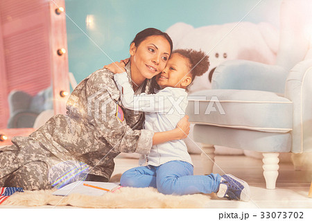 Little daughter cuddling her mother on the floor 33073702