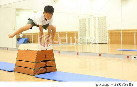 跳び箱を飛ぶ子供の写真素材