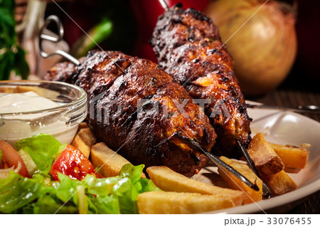 Grilled shish kebab served with fried chips 33076455