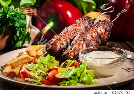 Grilled shish kebab served with fried chips 33076456