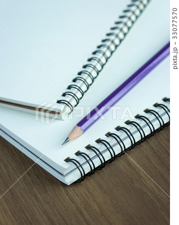 Close up pencil and spiral notebook on wood table Close up pencil and spiral notebook on wood table 33077570