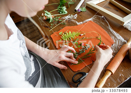 Woman making botanical plaster artwork in her home 33078493
