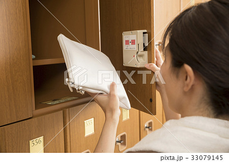 温泉施設のロッカーに荷物を入れる(取り出す)女性 33079145