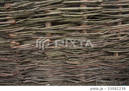 Wooden rustic fence made with chopped branches Wooden rustic fence made with chopped branches 33082236