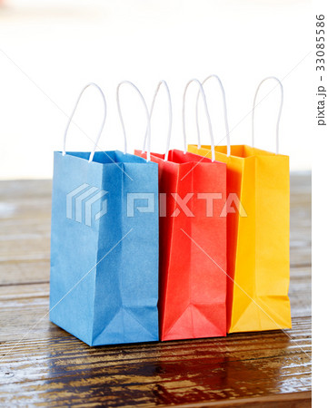 テーブルの上の3つのカラフルな紙袋 テーブルの上の3つのカラフルな紙袋 33085586