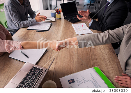 Two business teams sitting at both sides of table 33093030