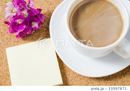 Cup of coffee with flowers on cork board. 33097671
