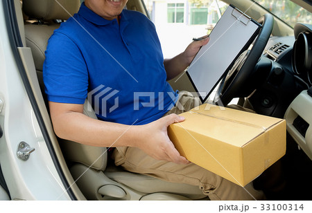 Delivery driver driving with parcels on seat. Delivery driver driving with parcels on seat. 33100314