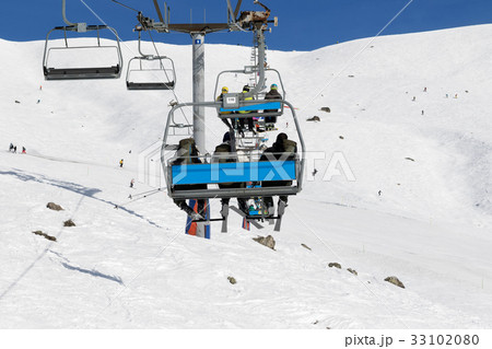 Skiers and snowboarders on chair-lift Skiers and snowboarders on chair-lift 33102080
