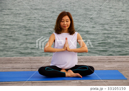 Woman is exercise yoga and meditation at pier Woman is exercise yoga and meditation at pier 33105150