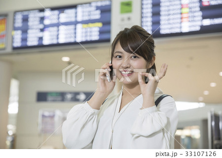 空港ロビーで通話をする若い女性 空港ロビーで通話をする若い女性 33107126