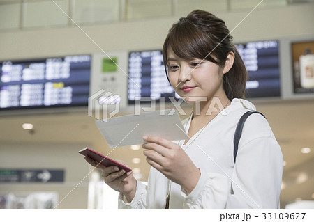 空港ロビーで航空券を確認する女性 33109627