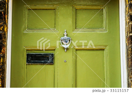 Door with brass knocker in the shape of a hand 33115157
