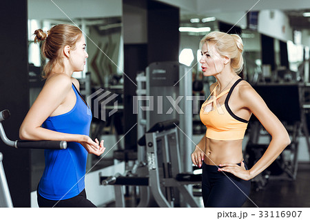 Two athletic blond women talking in the gym. Girl Two athletic blond women talking in the gym. Girl 33116907