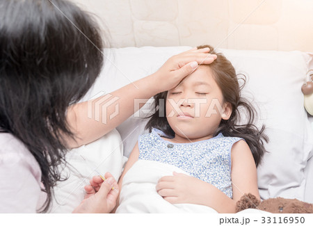 Mother measuring temperature of her ill kid by hand. Mother measuring temperature of her ill kid by hand. 33116950