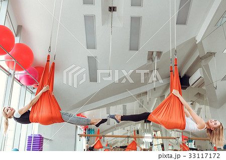 Fly yoga. two women practices anti-gravity yoga Fly yoga. two women practices anti-gravity yoga 33117172