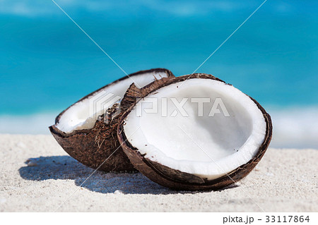 Broken brown coconut on sandy beach Broken brown coconut on sandy beach 33117864