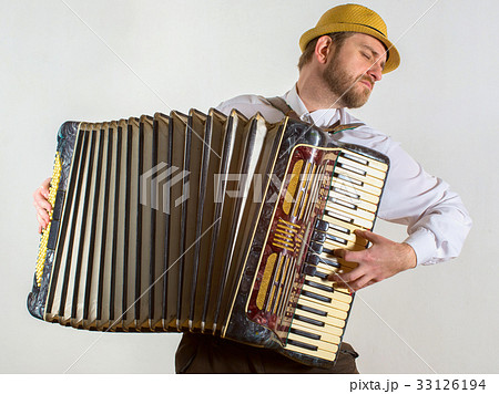 Portrait of man in straw hat playing on accordion Portrait of man in straw hat playing on accordion 33126194