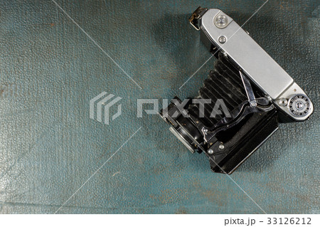 Old vintage camera on a blue scratched background. 33126212