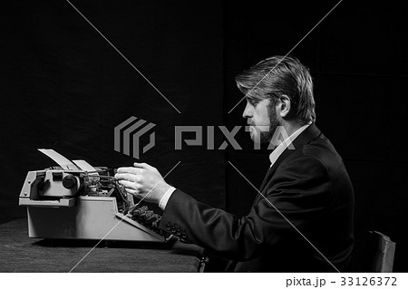 writer, man in a black jacket typing on typewriter 33126372