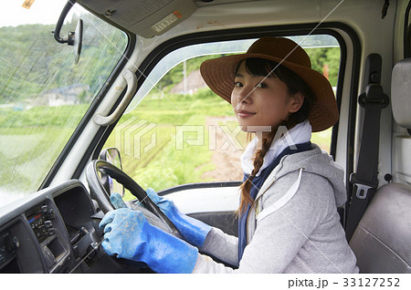 田植え 農作業 軽トラックを運転する女性の写真素材